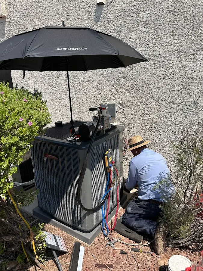 HVAC technician performing outdoor AC maintenance in Bonadelle Ranchos