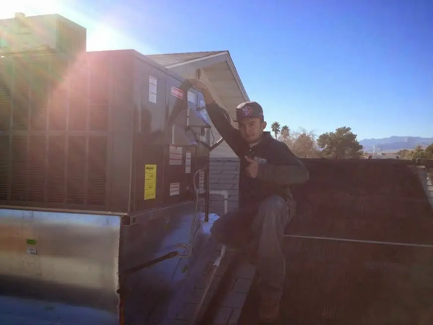 HVAC technician performing HVAC Inspection on a rooftop unit in Bonadelle Ranchos